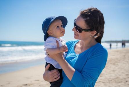 Mother and baby at the beach, sunny day.